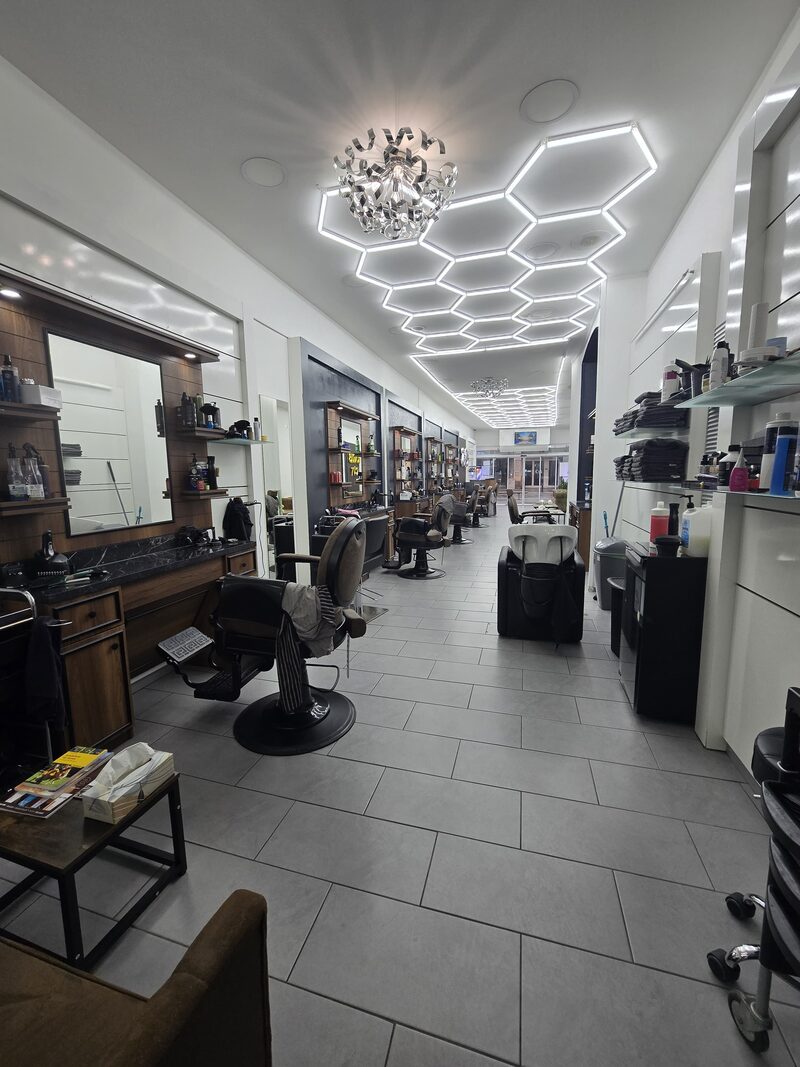 Blick in den Salon von Karls Cut mit Barber-Stühlen und Hexagon-LED-Beleuchtung