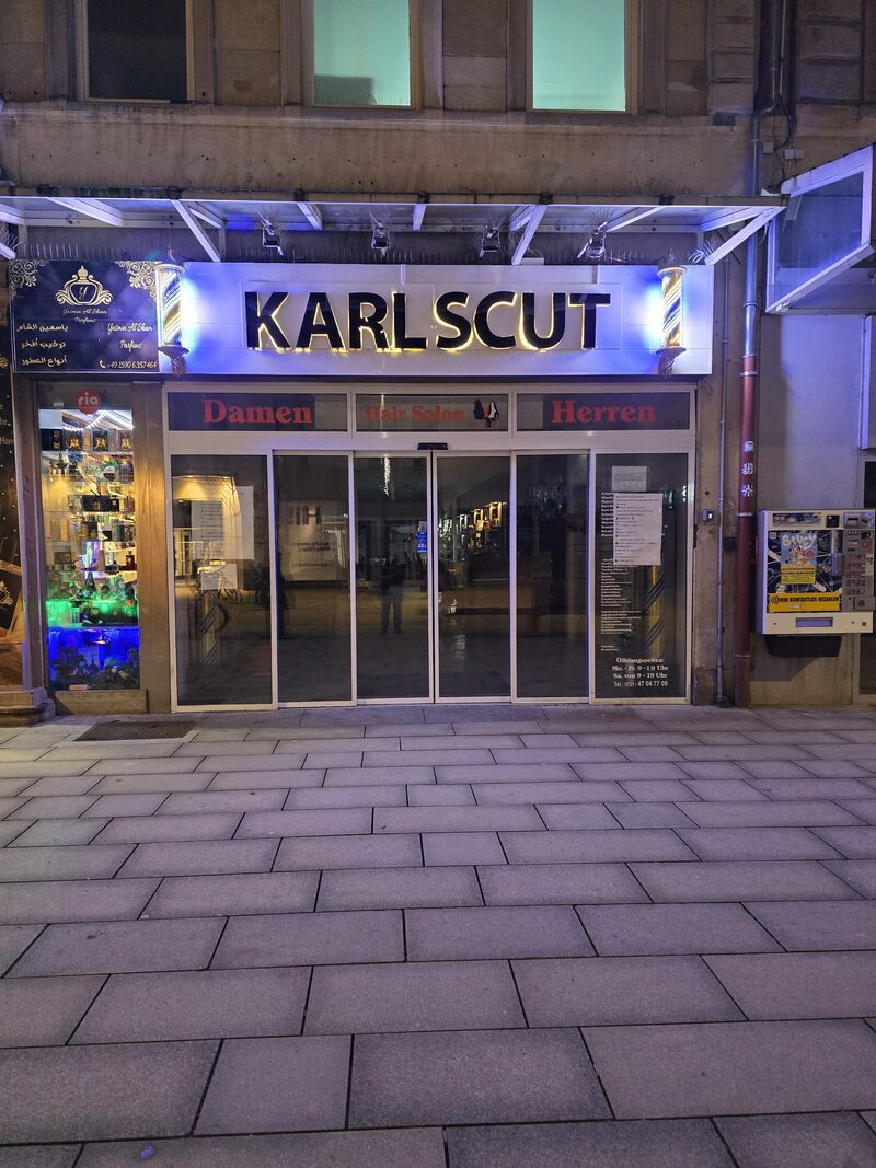 Beleuchtetes Schaufenster von Karls Cut in der Kaiserstraße bei Nacht